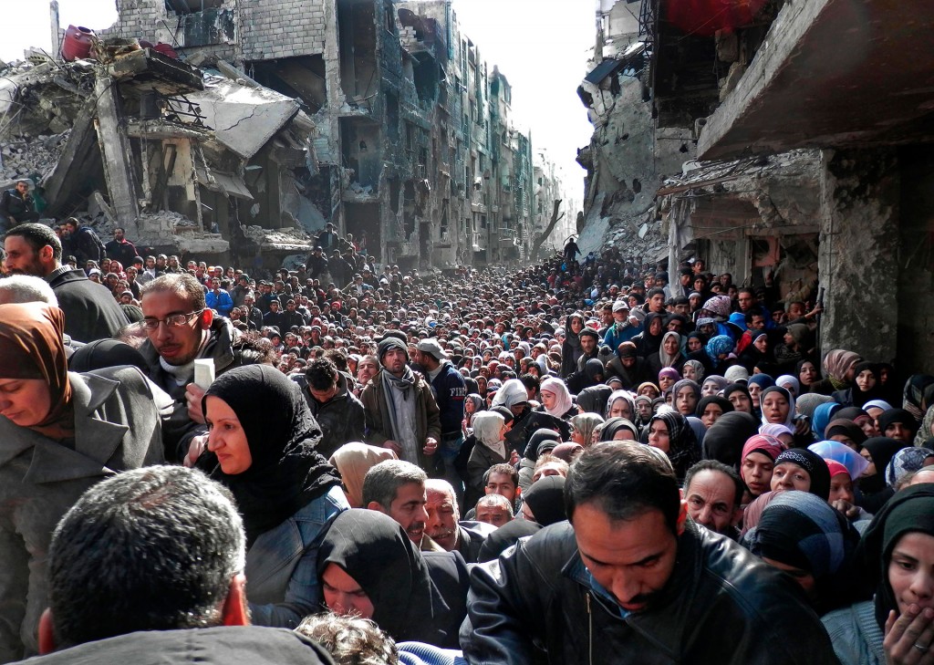 لاجئون فلسطينيون ينتظرون الحصول على مساعدات عذائيّة توزّعها وكالة أونروا في مخيم اليرموك للاجئين في سورية، جنوبي دمشق، يوم 31 كانون الثاني 2014- تصوير: رويترز